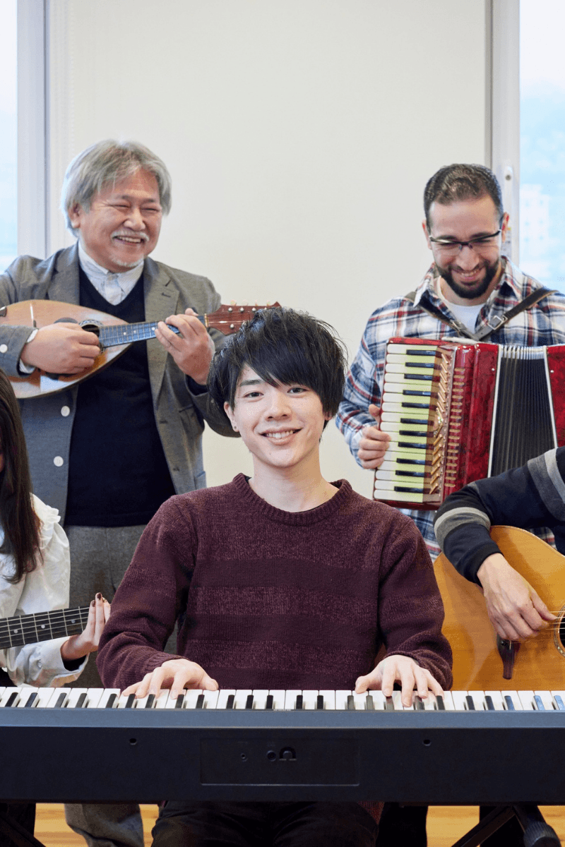 Musicians collaborating on a laptop and keyboard